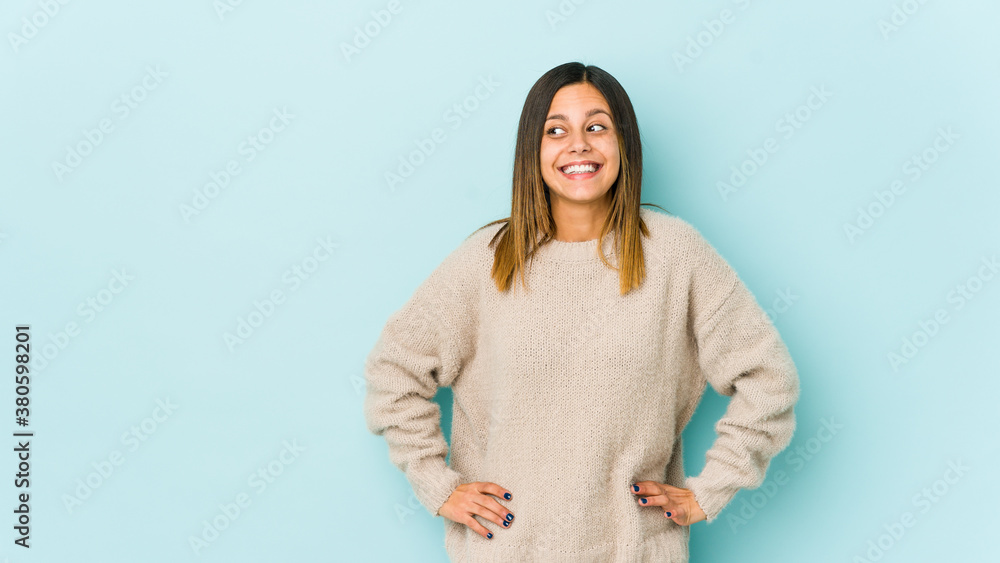 Young woman isolated on blue background laughs and closes eyes, feels relaxed and happy. Young woman isolated on blue background laughs and closes eyes, feels relaxed and happy.