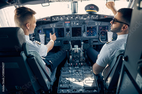 Two handsome man sitting on the chair in cockpit