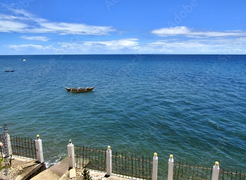 Blue sea with a fishing boat against the blue sky in the Philippines