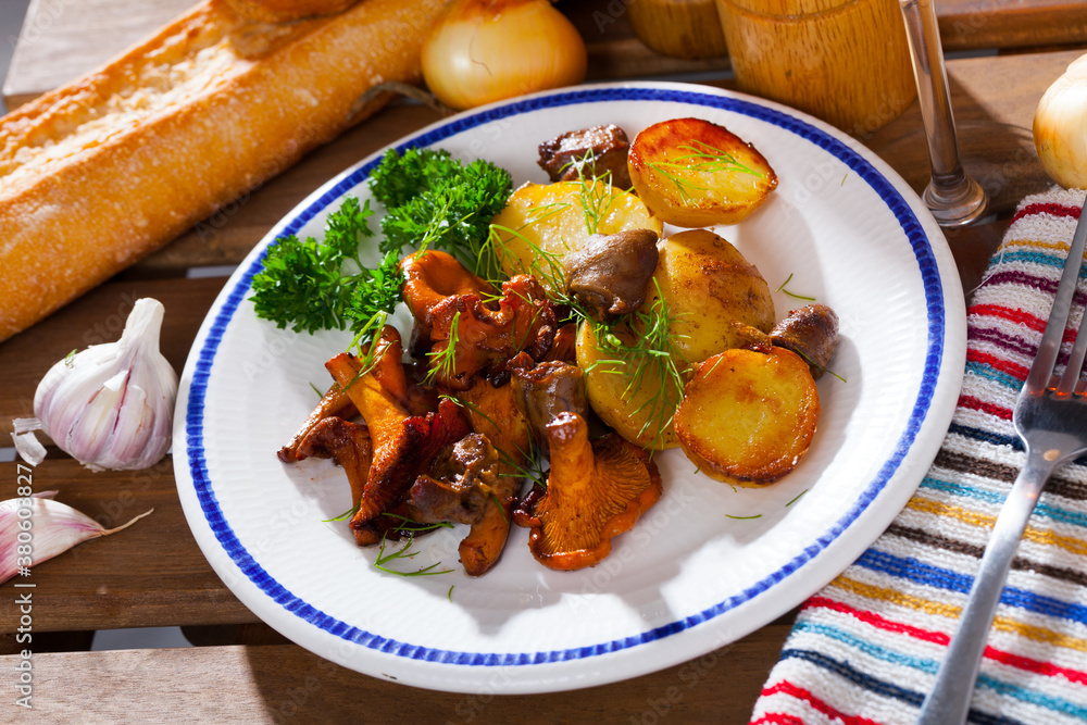 Delicious fried girolles with baked potatoes and chicken hearts garnished with fresh greens