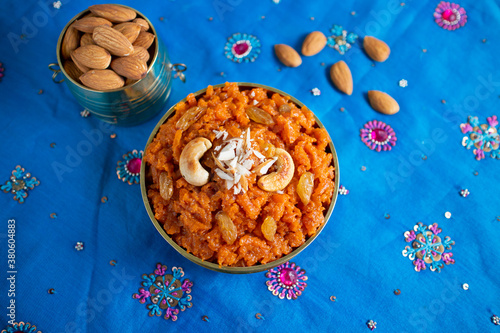 Indian Sweet carrot Halwa or Halva dessert festival sweet served in golden bowl  Mumbai, India for Dussehra, Diwali. Homemade Mithai with dry fruits and cashew nuts in traditional background. photo