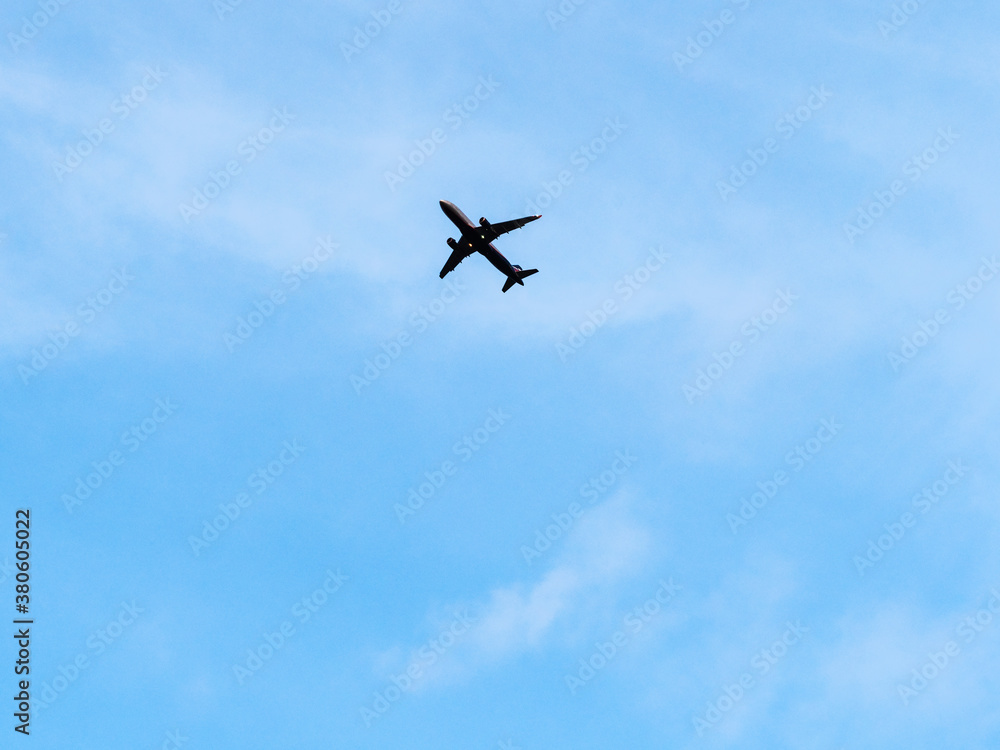 bottom view of airplane in blue evening sky bottom view of airplane in blue evening sky