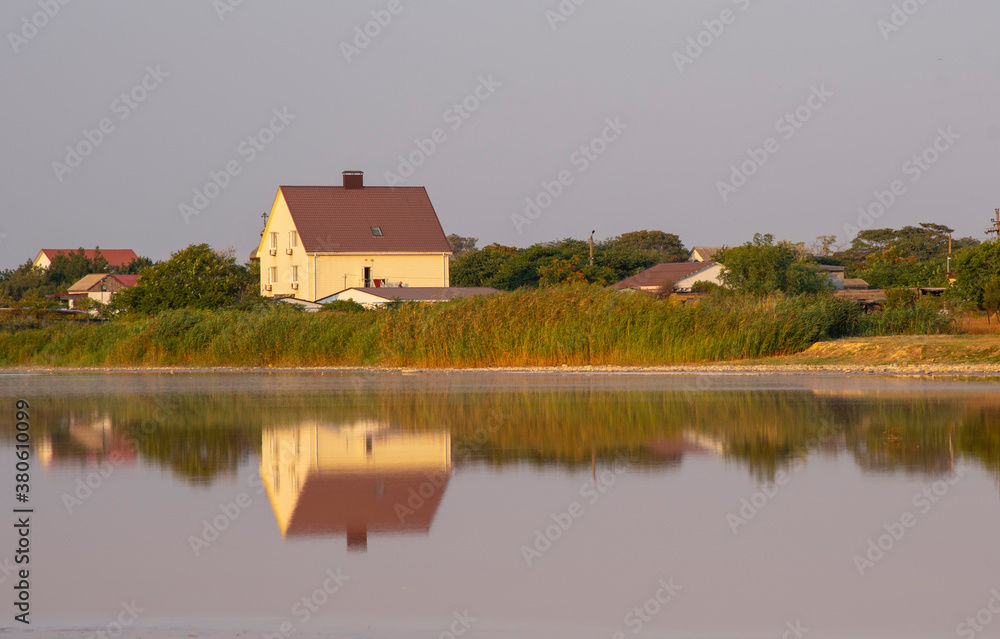 Yellow house on the lake shore, reflected in the water. Yellow house on the lake shore, reflected in the water.