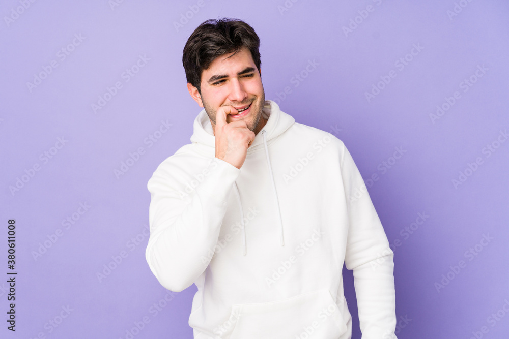 Young man isolated on purple background relaxed thinking about something looking at a copy space. Young man isolated on purple background relaxed thinking about something looking at a copy space.
