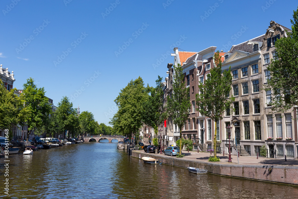Historical canal houses on the Keizersgracht in the center of the Amsterdam with a blue sky in the Netherlands.