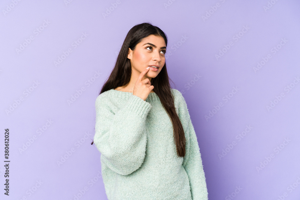 Young indian woman isolated on purple background looking sideways with doubtful and skeptical expression. Young indian woman isolated on purple background looking sideways with doubtful and skeptical expression.
