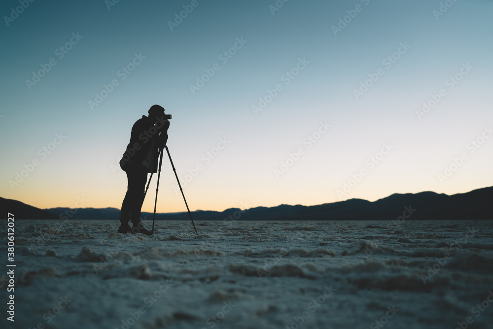 Unrecognizable man taking picture in evening