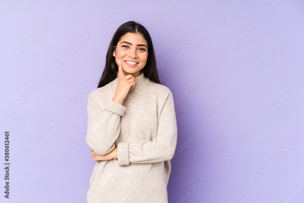 Young indian woman isolated on purple background smiling happy and confident, touching chin with hand. Young indian woman isolated on purple background smiling happy and confident, touching chin with hand.