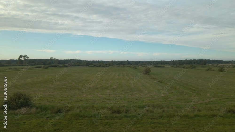 Aerial shot Green mown meadow, beautiful clouds on the horizon and forest, Debki Poland Aerial shot Green mown meadow, beautiful clouds on the horizon and forest, Debki Poland