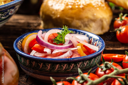 Canvas Print uzbek national salad achichuk with tomatoes and onion in a bowl with oriental or