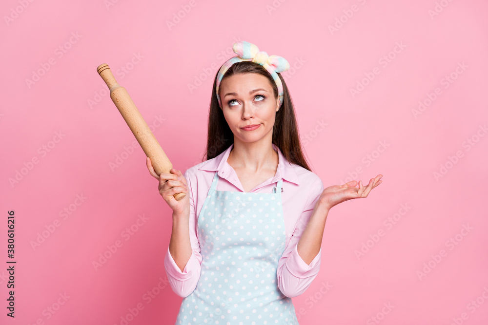 Portrait of unsure indifferent girl wife hold rolling pin look copyspace wear trendy stylish shirt isolated over pastel color background Portrait of unsure indifferent girl wife hold rolling pin look copyspace wear trendy stylish shirt isolated over pastel color background