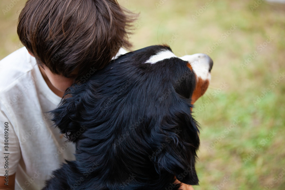 Child embraces his dog resting his head as a sign of affection and comfort.