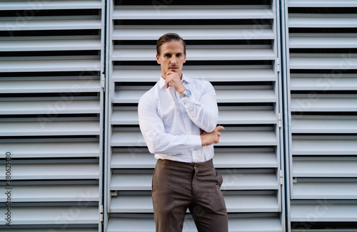 Confident businessman standing next to wall