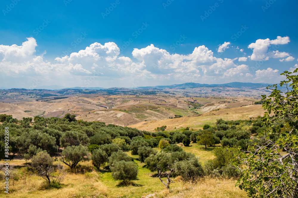 Craco, Matera, Italy. View from the top of the endless and desolate hills of Basilicata. The deserted countryside, the olive trees and the cultivated fields.