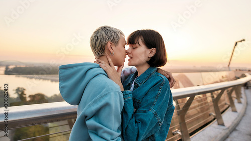 Young passionate lesbian couple going to kiss, Two girls enjoying romantic moments together at sunrise © Svitlana