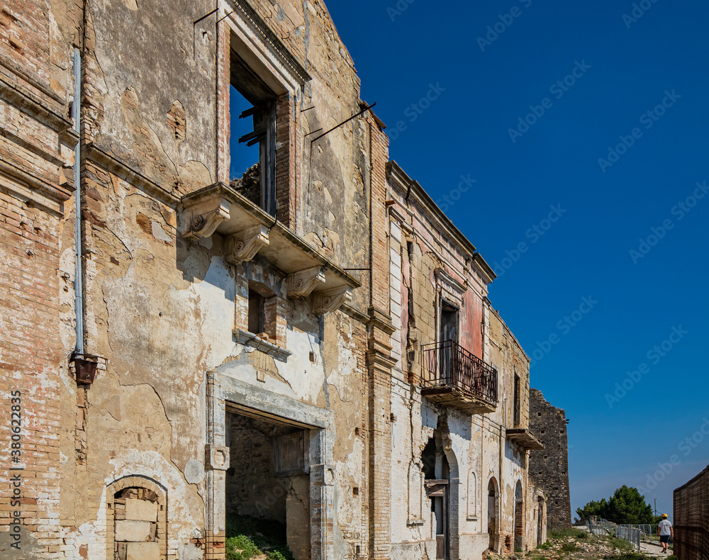 Craco, Matera, Basilicata, Italy. Ghost town destroyed and abandoned following a landslide. Collapsed houses and the remains invaded by vegetation. Broken walls, windows and doors, crumbling balconies