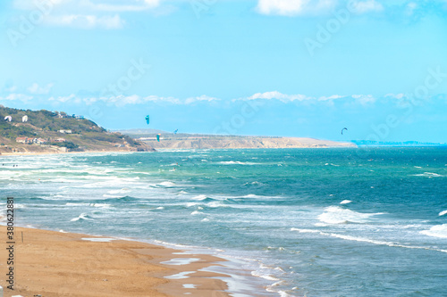Wavy sea and blueish sky in Kilyos, peoples kitesurfing at the far end, Black Sea Region in Istanbul