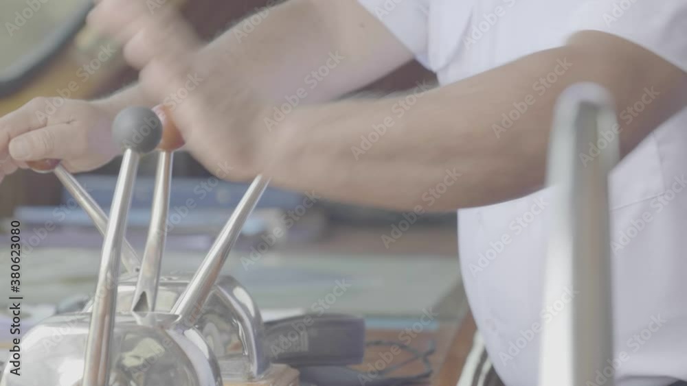 The levers on the bridge of a cruise are being used by the captain to sail. The levers on the bridge of a cruise are being used by the captain to sail.