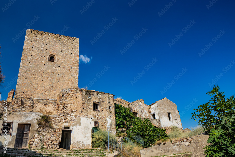 Craco, Matera, Basilicata, Italy. The ghost town destroyed by a landslide. The collapsed houses and the remains invaded by vegetation. The ancient watchtower still standing overlooks the city.