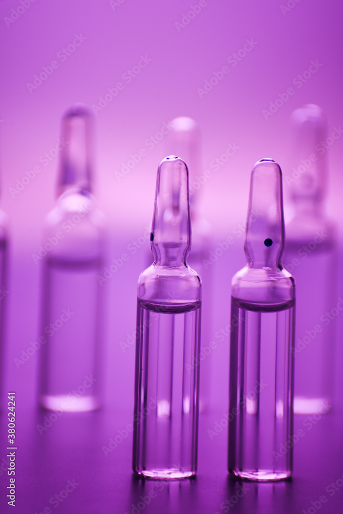 glass medicine ampoules with liquid in pink light glass medicine ampoules with liquid in pink light