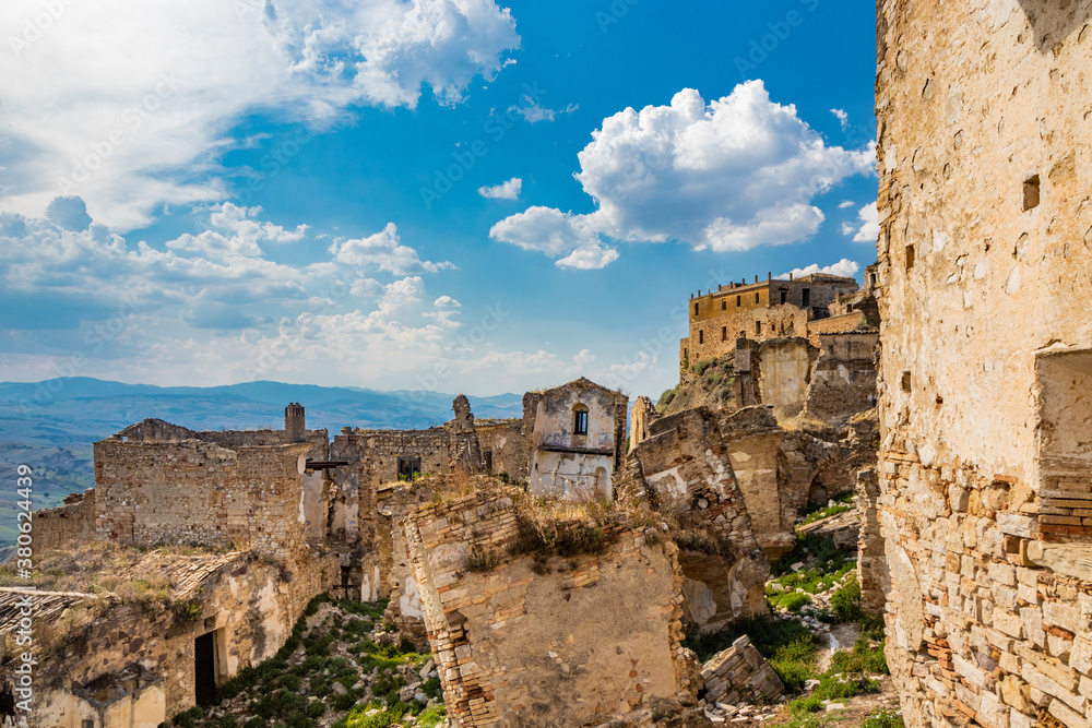 Craco, Matera, Basilicata, Italy. The ghost town destroyed and abandoned following a landslide. The collapsed houses and the remains invaded by vegetation, stones and debris. Broken doors and windows.