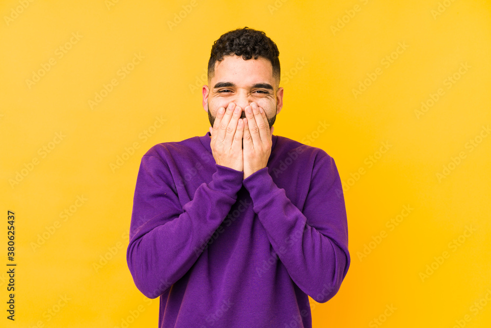 Young mixed race arabic man isolated laughing about something, covering mouth with hands. Young mixed race arabic man isolated laughing about something, covering mouth with hands.