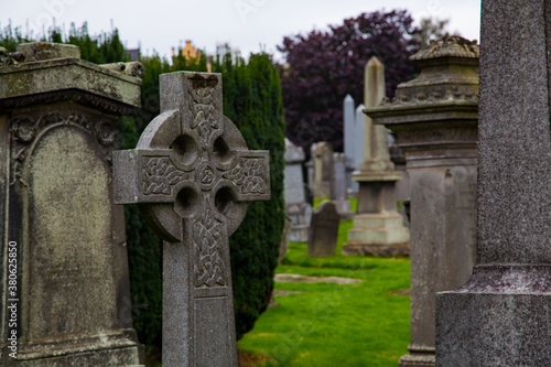 Lápida de cruz celta adornado con deterioro y lápidas de fondo