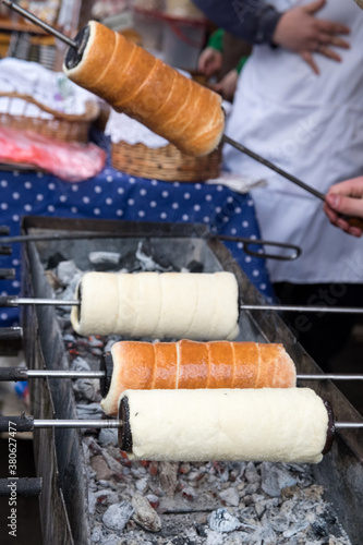 Sweet hungarian and Czech dessert - baked kurtosh kalach (Kurtoskalacs) or trdlo on the holiday market in Serbia photo