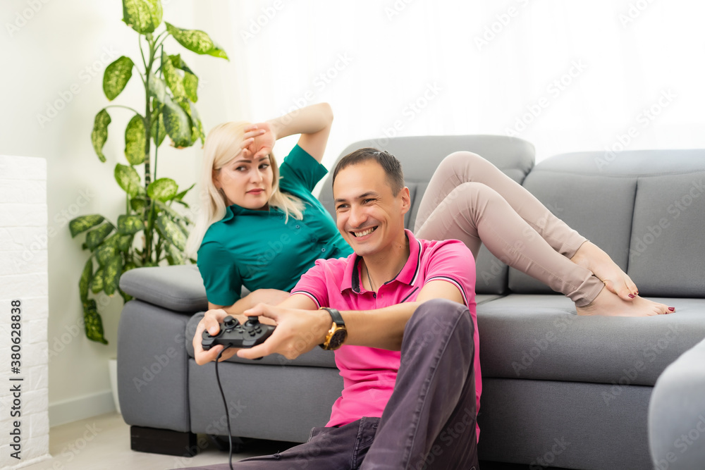 Obraz premium Man and woman playing video games with joystick at home.
