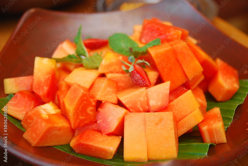 fresh papaya fruit slices decorated with mint leaves fresh papaya fruit slices decorated with mint leaves