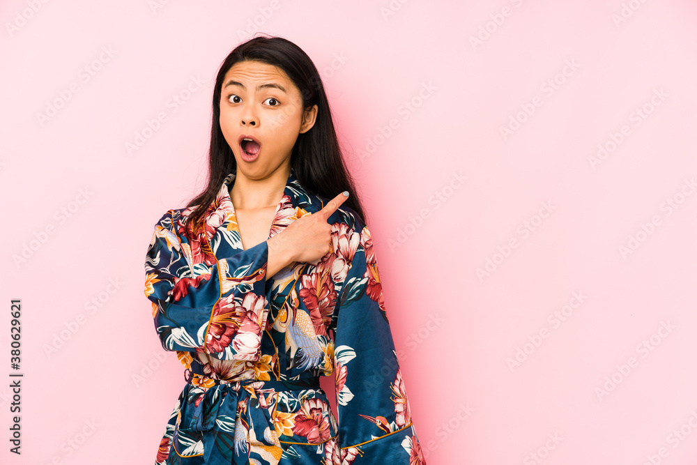 Young chinese woman wearing a asiatic pijama isolated relaxed thinking about something looking at a copy space. Young chinese woman wearing a asiatic pijama isolated relaxed thinking about something looking at a copy space.