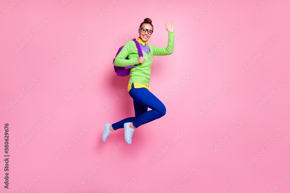 Full size photo high school girl jump ready university education wave hand greet teacher classmates hold backpack wear green shirt blue pants trousers isolated pastel color background