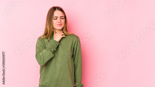 Young caucasian woman isolated on pink background suffers pain in throat due a virus or infection. © Asier