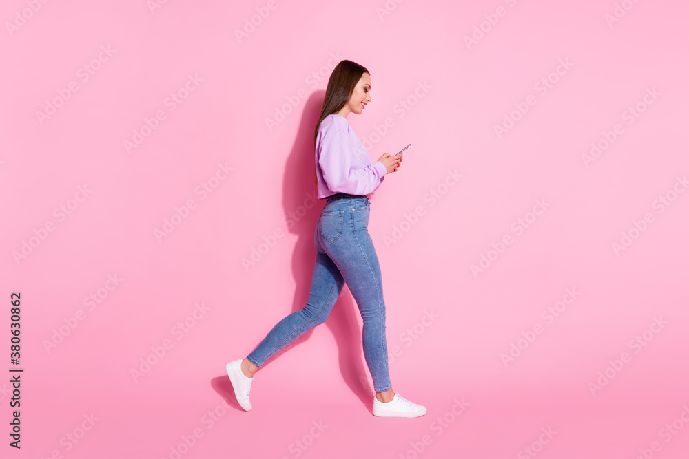Full size profile side photo positive blogger girl go walk copyspace use cellphone read social media news repost share wear lilac violet jumper isolated pastel color background