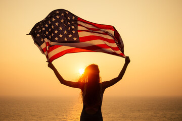 woman holding USA flag and looking at sunrice