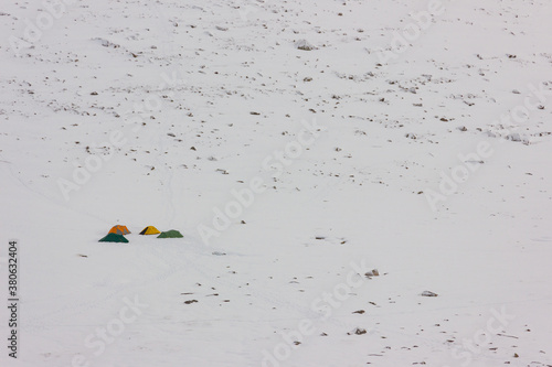 Four colourful tents set on the white snow during winter in the mountain.