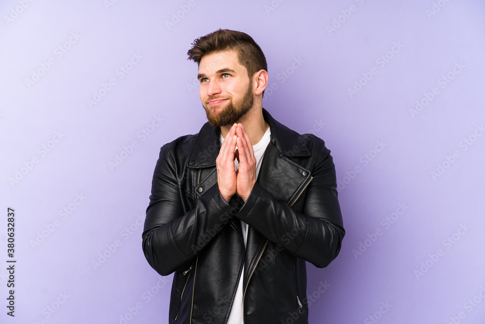 Young man isolated on purple background making up plan in mind, setting up an idea. Young man isolated on purple background making up plan in mind, setting up an idea.