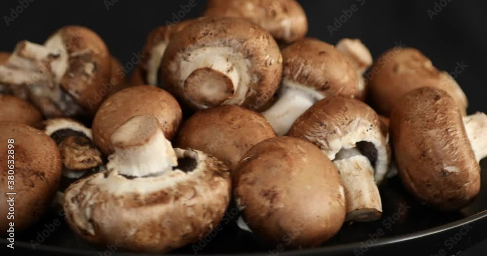 Fresh Raw Royal Champignon Mushrooms Rotating on black background Fresh Raw Royal Champignon Mushrooms Rotating on black background