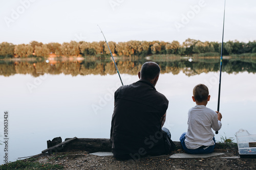 boy fishing with his grandfather outdoors at the lake