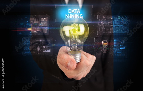 Businessman holding lightbulb with DATA MINING inscription, online security idea concept