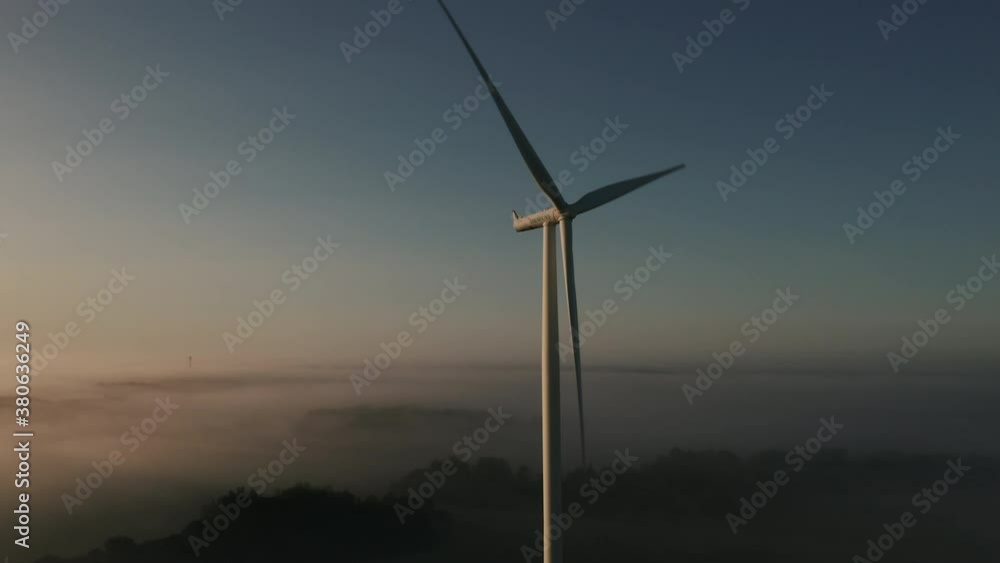 Aerial view of an electric Siemens wind turbine in early morning fog. Aerial view of an electric Siemens wind turbine in early morning fog.