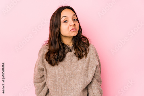 Young mixed race hispanic woman isolated shrugs shoulders and open eyes confused.