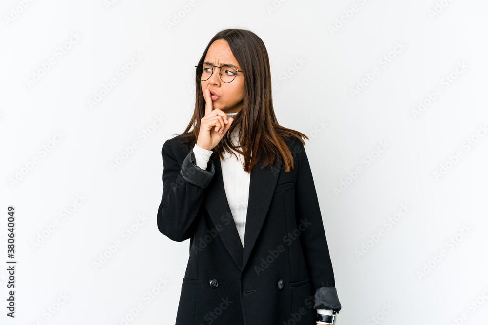 Young mixed race business woman isolated on white background keeping a secret or asking for silence. Young mixed race business woman isolated on white background keeping a secret or asking for silence.