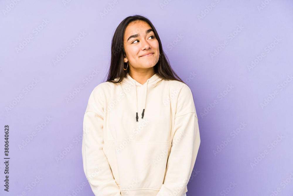 Young woman isolated on a purple background dreaming of achieving goals and purposes Young woman isolated on a purple background dreaming of achieving goals and purposes
