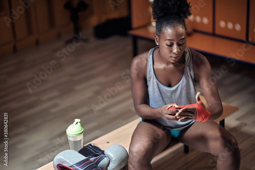A young female boxer is putting her equipment photo
