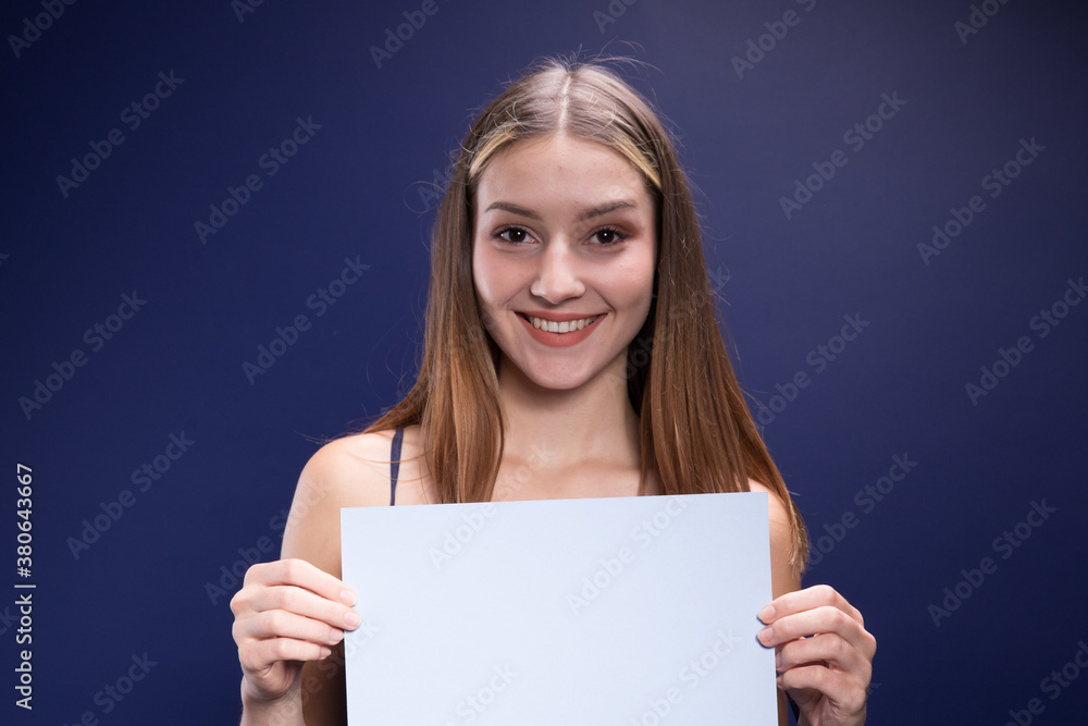 Beautiful brunette holds a colored blank page. Beautiful brunette holds a colored blank page.
