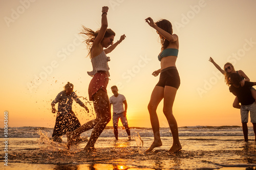 multicultural multinational happy people running into the sun carefree and happiness, vacation on sea © yurakrasil