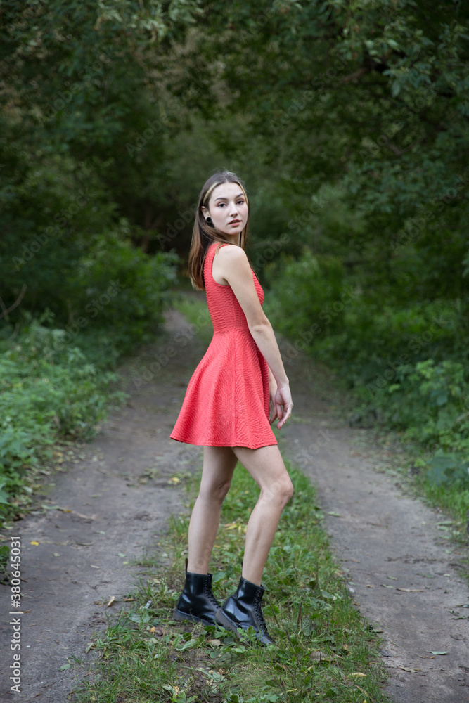 Portrait of a beautiful brunette outdoors on a green forest background. Portrait of a beautiful brunette outdoors on a green forest background.