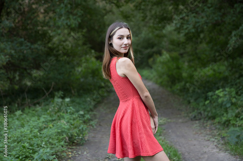 Portrait of a beautiful brunette outdoors on a green forest background.