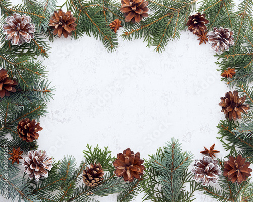 Christmas and Happy New Year light white background. Frame with fir branches, cones. Stone backdrop with copy space.